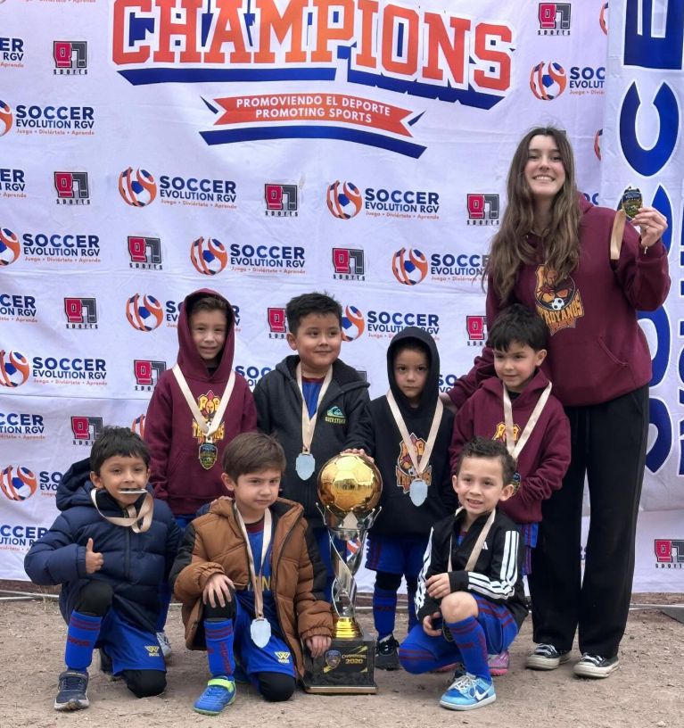 Los más pequeños del club con sus medallas y el trofeo de campeones